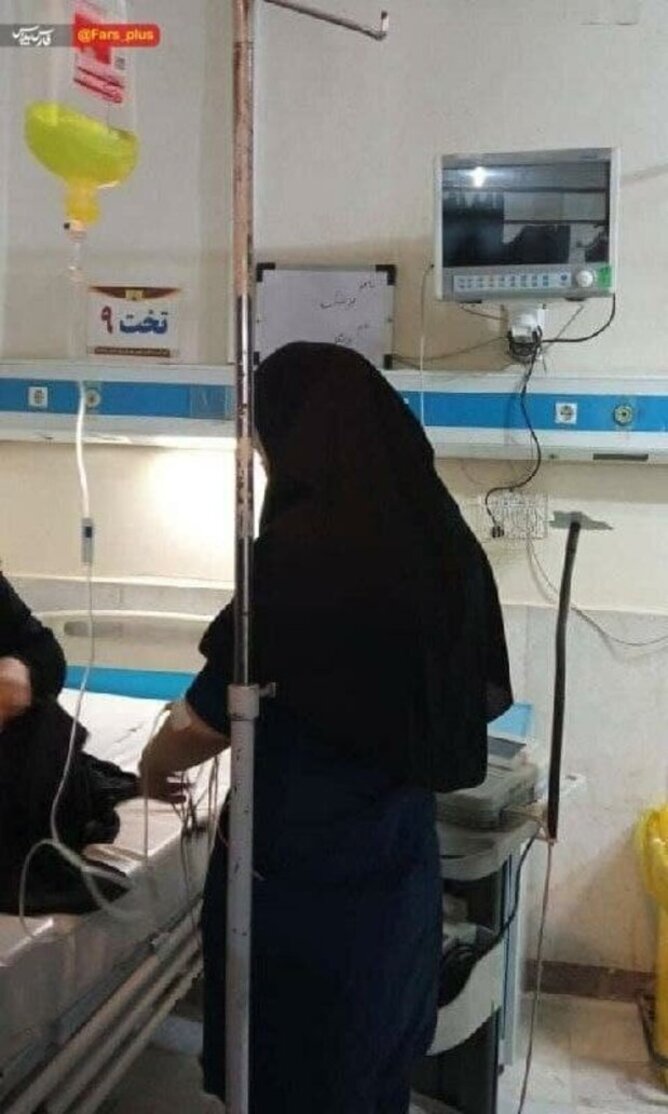 تصویری تکان دهنده از پرستاری که با سرم به دست به حال بیماران رسیدگی می‌کند
